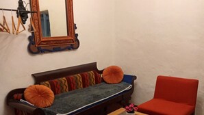 A living room with a sofa, two armchairs, a coffee table, a chandelier, and a mirror on the wall. - Cozy loft in the historic center with washing machine (Cusco)