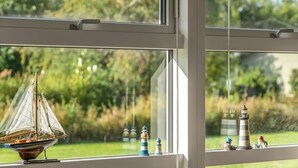 A window with a view of a grassy area and a model ship. - "Galmand" -  from the sea by Interhome (Hals)