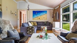 A modern living room with a grey sofa, a coffee table with decorative items, and a painting of a beach scene. - "Galmand" -  from the sea by Interhome (Hals)
