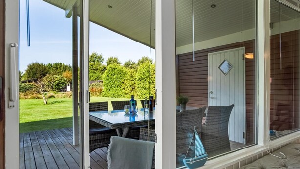 An open deck with a glass door leading to a patio area. - "Galmand" -  from the sea by Interhome (Hals)