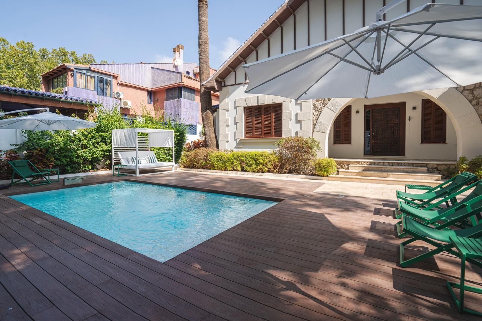 Een buitenzwembad, parasols voor strand/zwembad