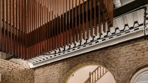 A spacious interior with a stone wall, a staircase, and a framed picture on the wall. - La moderna suites (Málaga)