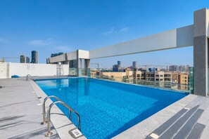 Una piscina en la azotea con vista despejada al horizonte de la ciudad.
