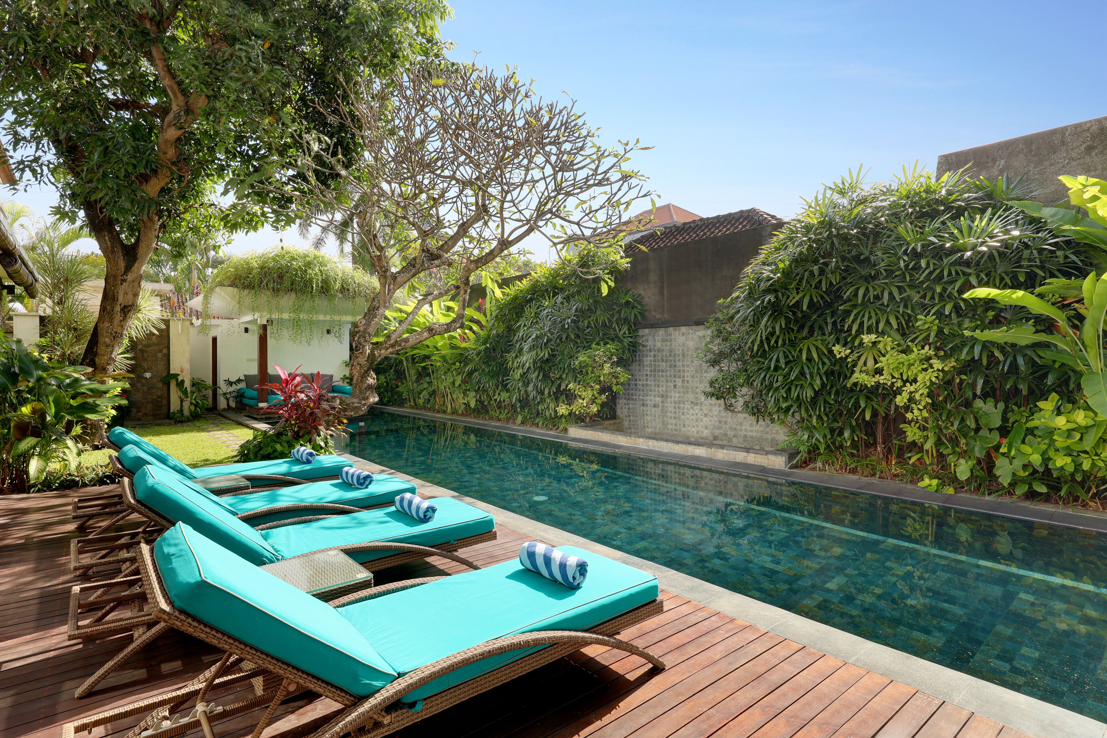 A poolside area with lounge chairs and a clear pool.