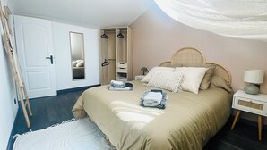 Un dormitorio con cama, mesita de noche, lámpara, armario y espejo.