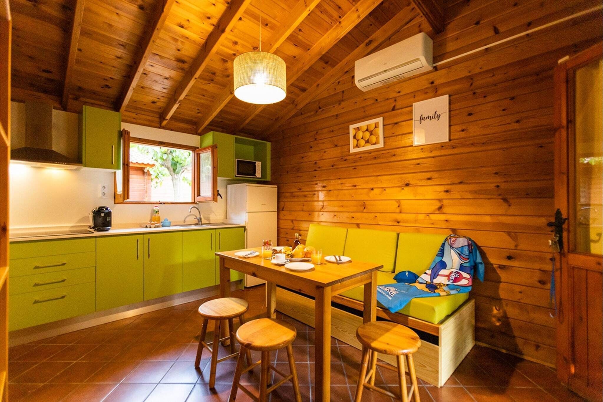 Una cucina accogliente in stile chalet, con pareti in legno, un tavolo da pranzo, sgabelli e una panca.