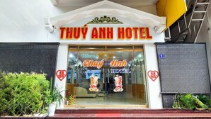Der Eingang zum Thuy Anh Hotel, mit einem Schild über der Tür und einem Willkommensschild im Inneren.