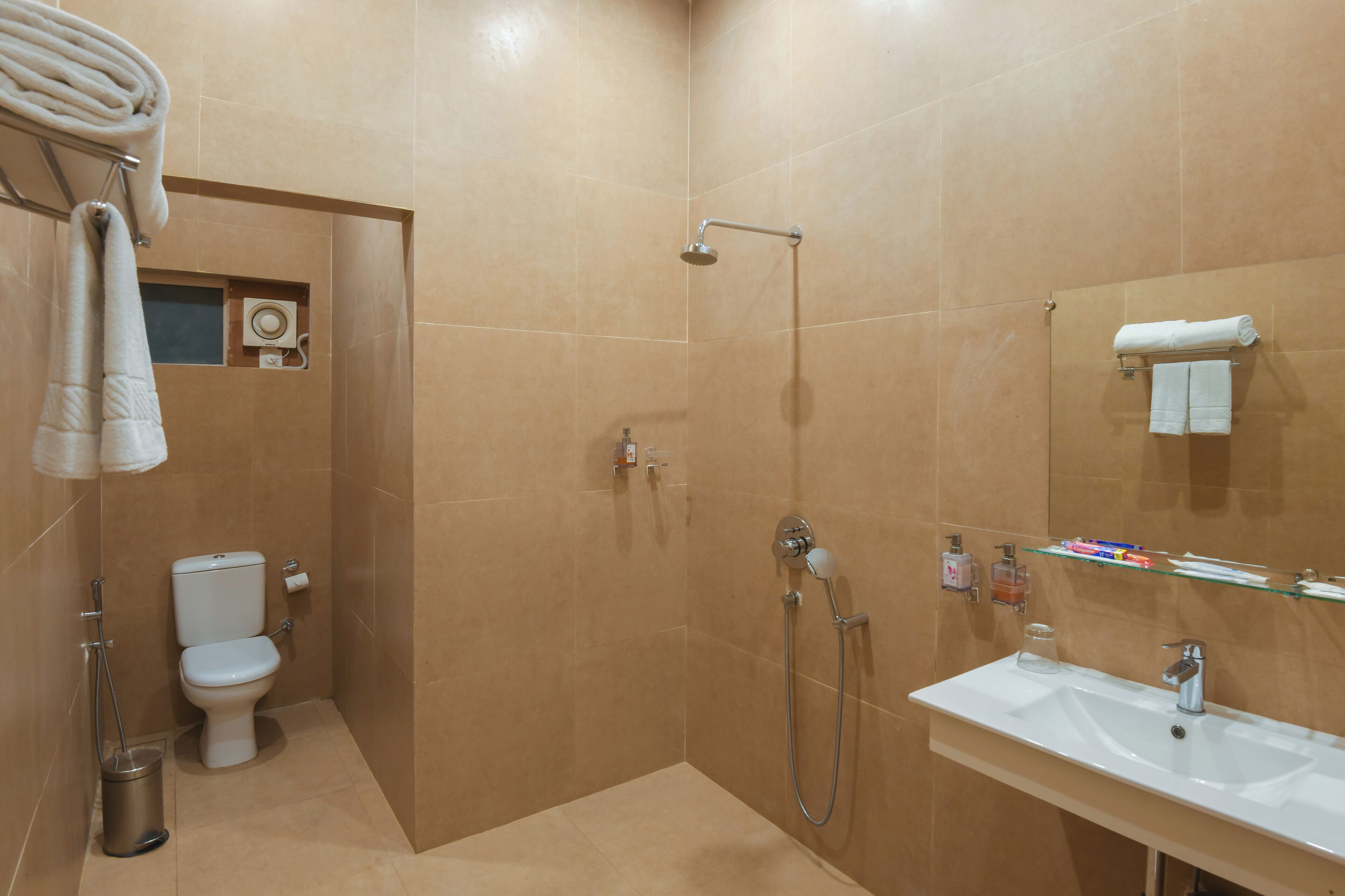 A bathroom with a shower, toilet, and sink.