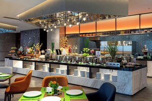 A modern restaurant with a central bar area, seating arrangements, and a variety of food and drink options.