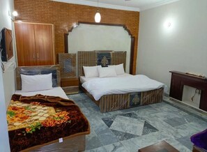 Una camera da letto con un letto, un armadio, un tavolino e una testiera decorativa.