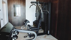 A gym with a wall-mounted mirror, a pull-up bar, and a bench. - Pana Boutique Hotel (Shymkent)