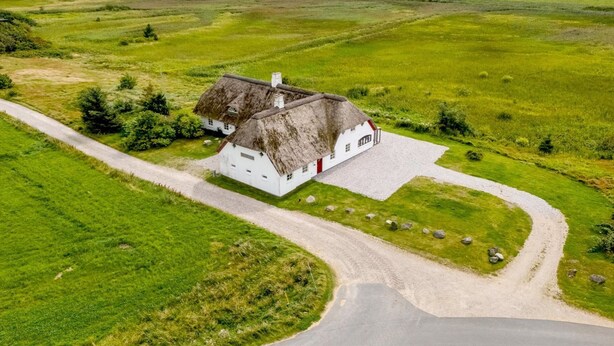 A white house with a thatched roof surrounded by green fields and a gravel path. - "Darleen" - 850m to the fjord by Interhome (Vemb)