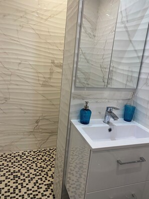 Chuveiro, secador de cabelo, toalhas de banho, sabonete