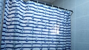 A bathroom with a striped shower curtain featuring anchor patterns. - Favour home (Abuja)