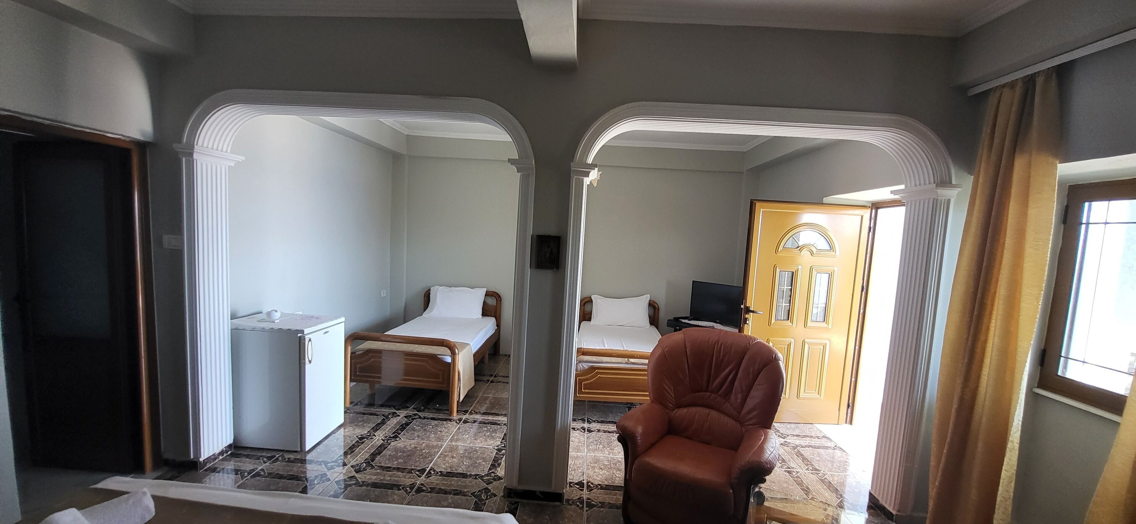 A hotel room with a bed, a chair, a desk, and a television.