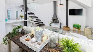 A modern living room with a staircase, a fireplace, and a flat-screen TV. - Solaga - Noemi Centro (Málaga)