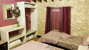 A bedroom with two beds, a wardrobe, and a mirror.