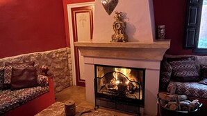 A living room with a fireplace, a sofa, a coffee table, and a patterned rug.