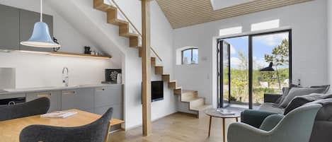 Departamento Deluxe, vista al jardín | Área de sala de estar | Televisión y piso con calefacción