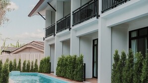 A modern building with a swimming pool, multiple balconies, and a clear sky. - Radateeree Boutique Resort (Chiang Mai)