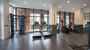 Un gimnasio moderno con cintas de correr, elípticas y equipo de pesas.