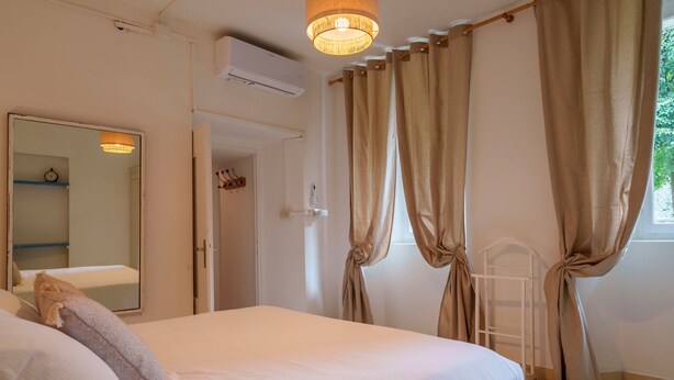 A bedroom with a bed, a mirror, curtains, and a window. - Beach Lake Bellagio by Wonderful Italy (Bellagio)