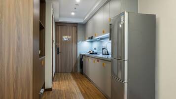 Una cocina moderna con armarios de madera, un refrigerador de acero inoxidable y una estufa empotrada.