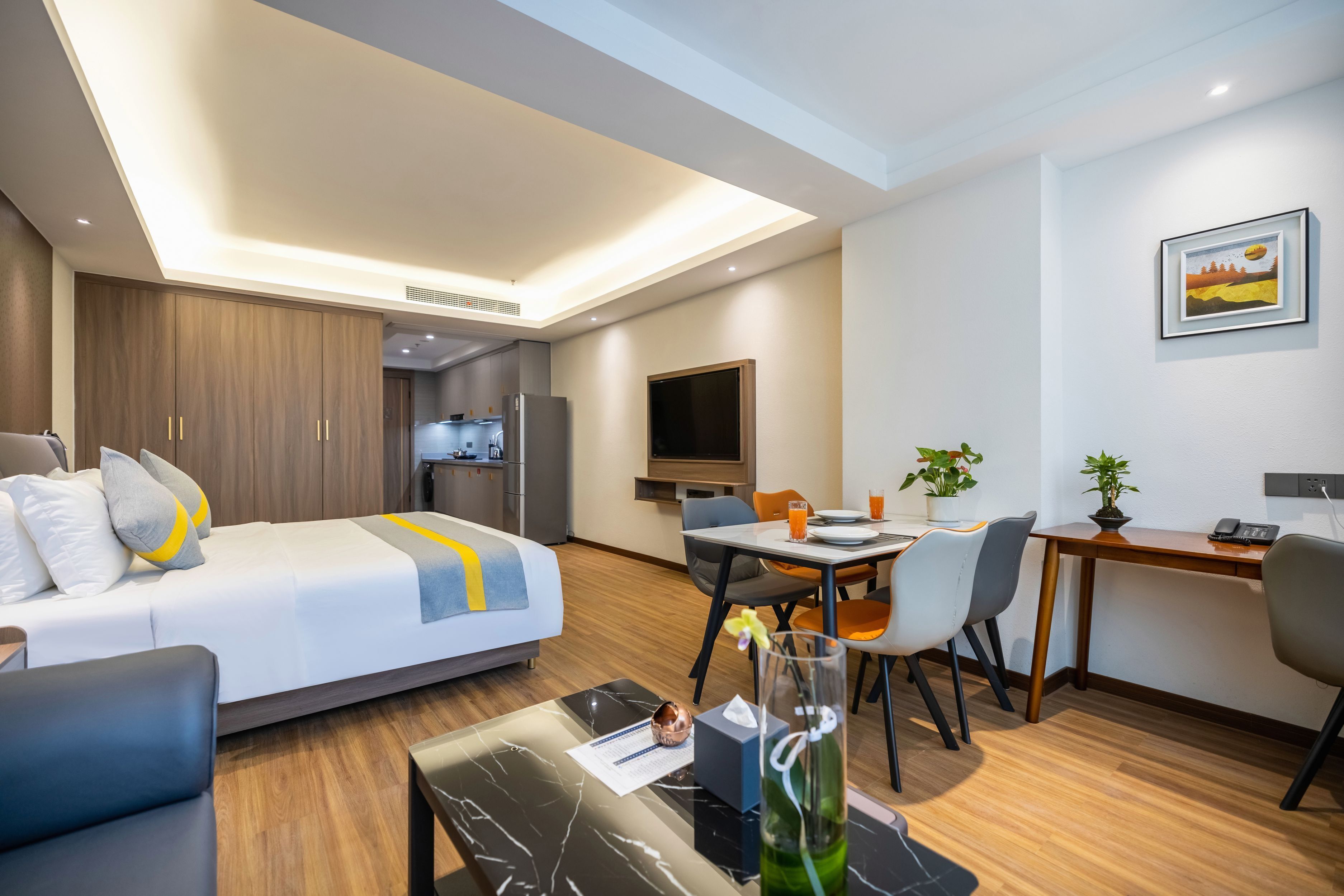 Une chambre d’hôtel moderne équipée d’un lit, d’un bureau, d’une table à manger et d’un téléviseur.