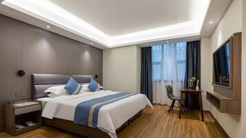 Una habitación de hotel moderna con una cama grande, una mesita de noche y un televisor montado en la pared.