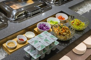 Un bufé con diversas opciones de comida y salsas.
