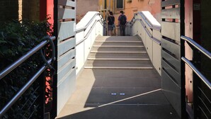 A narrow stairway leading to a building with a red frame and metal railings. - Painters House Biennale Arsenale (Venice)