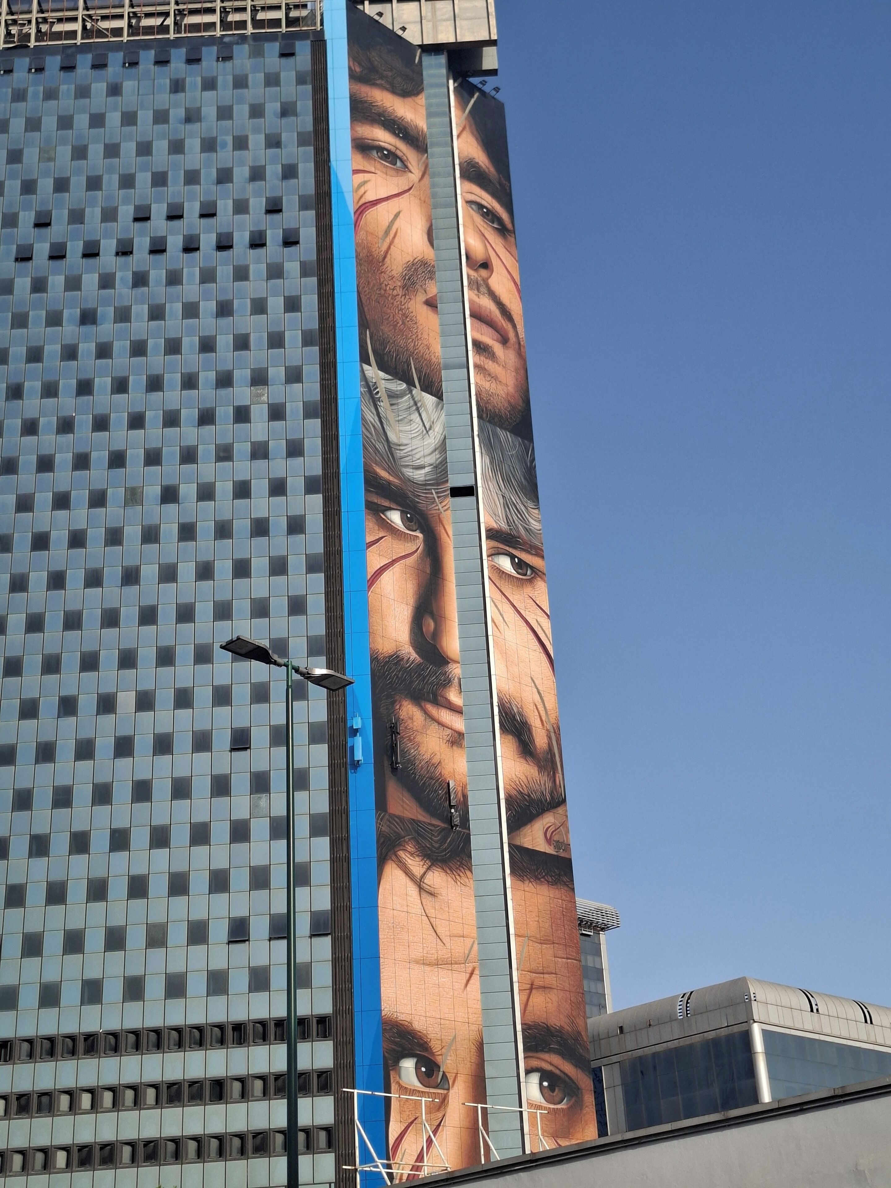 A tall building with a large, detailed mural on its side.