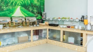 A breakfast bar with a glass enclosure, a painting of a green landscape, and various food items. - Le Soleil Hotel (Nha Trang)