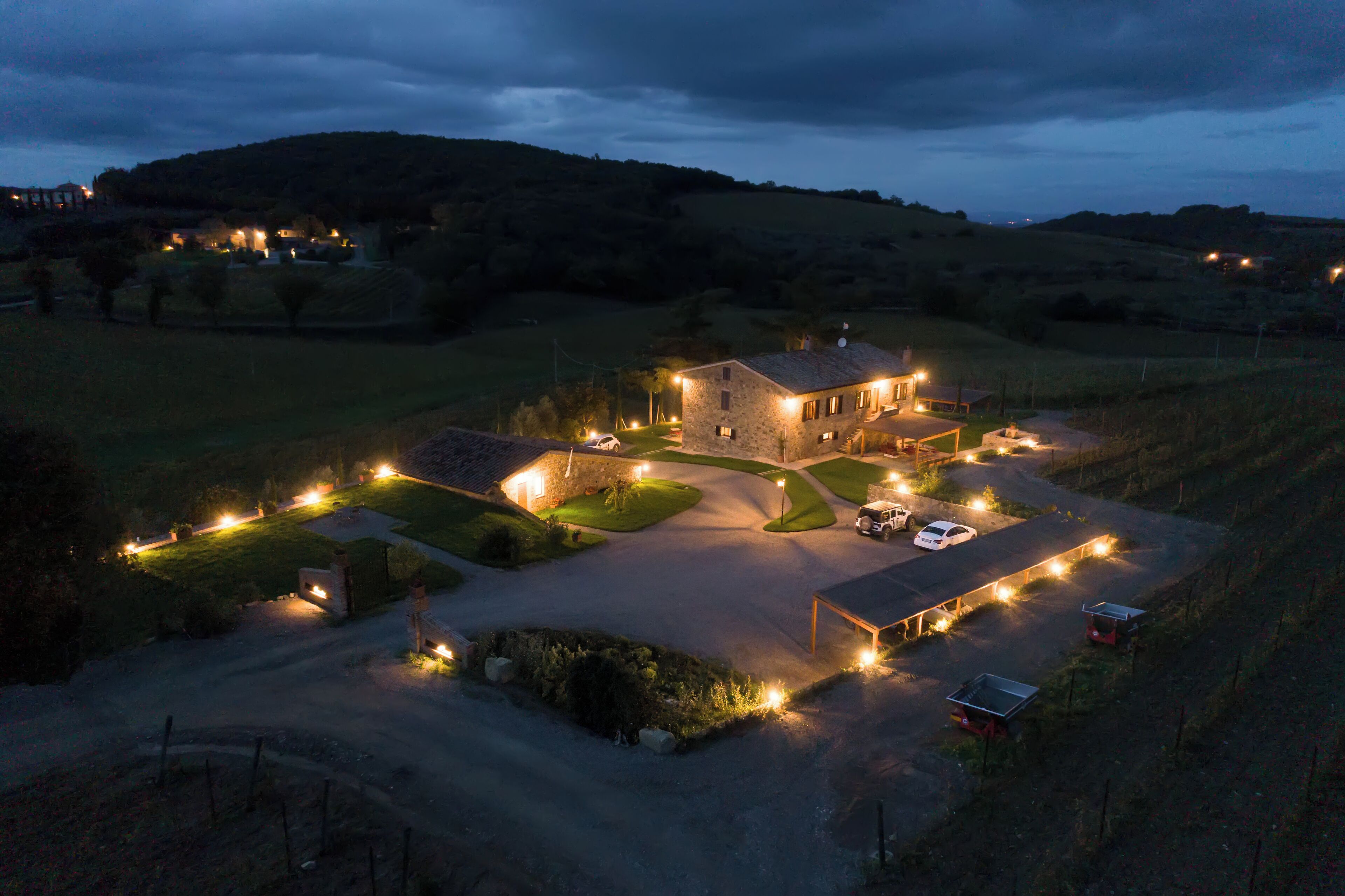 Une maison en pierre avec une allée pavée et un petit espace de stationnement.