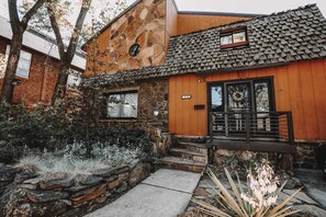 A rustic building with a stone facade, wooden siding, and a tiled roof.