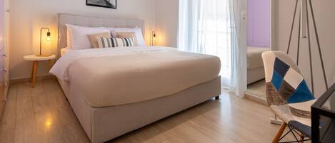 A bedroom with a bed, bedside tables, a chair, and a window with curtains.