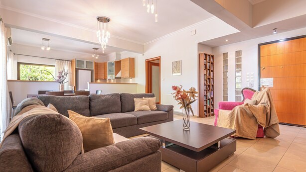 Ein modernes Wohnzimmer mit einem Ecksofa, einem Couchtisch und einem Bücherregal.
