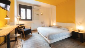 Een slaapkamer met een bed, een bureau en een stoel.