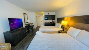 A hotel room with a bed, a TV, a desk, and a kitchenette. - LA82 Beautiful Studio on the beach + pool+ hot tub (Myrtle Beach)