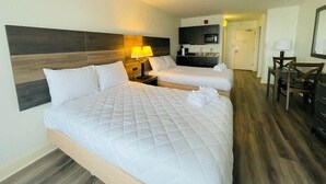A hotel room with two beds, a desk, a chair, a microwave, and a TV. - LA105 Amazing Ocean View studio on the beach+ pool (Myrtle Beach)