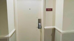 A white door with a number plate '1105' and a keyhole, leading to a room with a patterned floor. - LA105 Amazing Ocean View studio on the beach+ pool (Myrtle Beach)