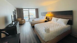 A hotel room with two beds, a desk, a chair, a TV, and a window with curtains. - LA105 Amazing Ocean View studio on the beach+ pool (Myrtle Beach)