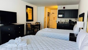 A hotel room with two beds, a TV, a desk, and a kitchenette. - LA11 Great condo right on the beach+pool+Hot tub (Myrtle Beach)