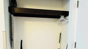 A narrow hallway with a wooden floor, a ceiling-mounted shelf, a vacuum cleaner, a broom, and a bucket. - LA11 Great condo right on the beach+pool+Hot tub (Myrtle Beach)