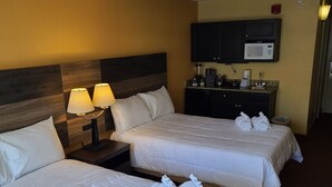 A hotel room with two beds, a nightstand with lamps, a microwave, and a small kitchenette. - LA12 Wonderful condo on the beach + pool + Hot tub (Myrtle Beach)