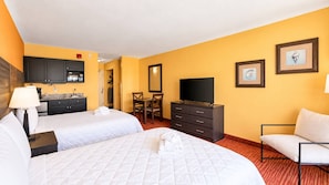 A hotel room with two beds, a television, a desk, and a chair.