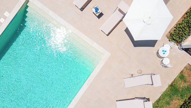 An aerial view of a swimming pool with lounge chairs and umbrellas.
