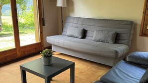 A modern living room with a grey sofa, a small table with a plant, and a lamp. - Racons del Pedraforca (Saldes)