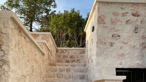 A stone staircase leading to a building with a metal gate. - Atlas homes (Demre)