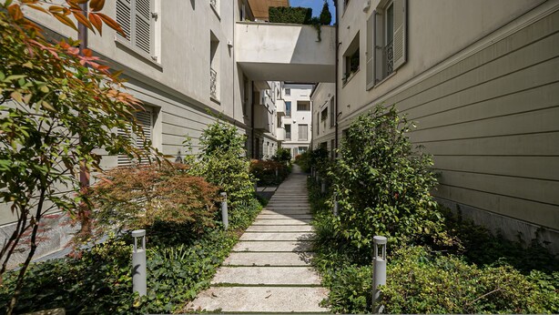 A narrow pathway flanked by buildings with balconies, leading to a central building with a visible entrance. - Volta 40 - B in Monza (Monza)